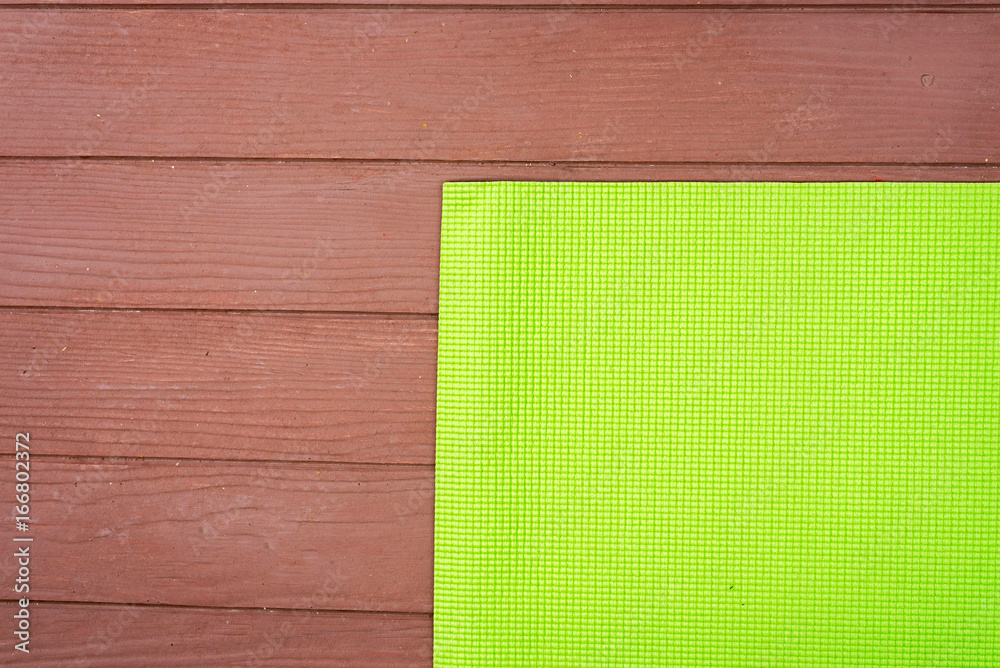 Fototapeta premium yoga green mat for practicing yoga on wood floor
