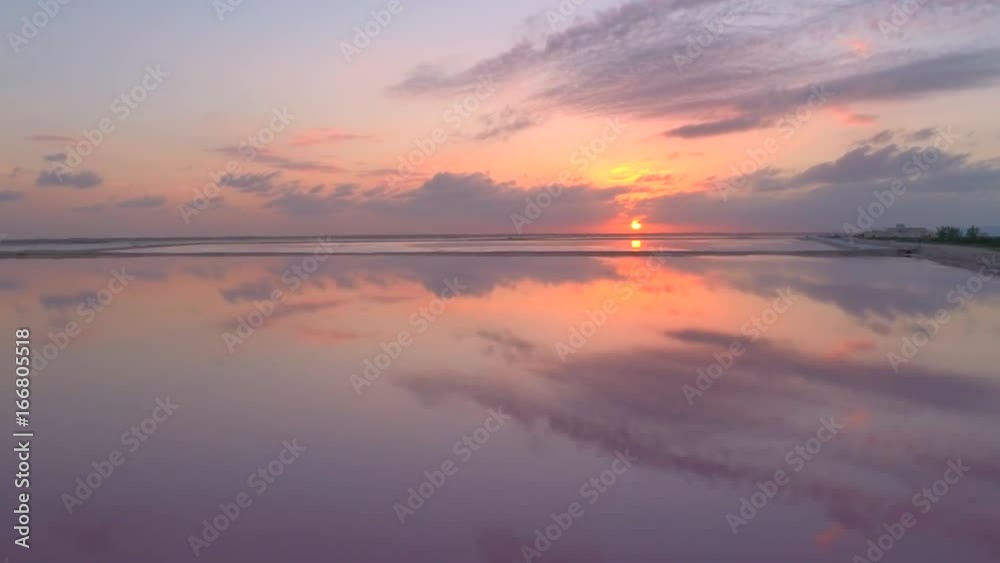 AERIAL: Flying above stunning salt pans & salt evaporation ponds stretching to the horizon at pink sunset. Gorgeous sky reflection in calm glassy water surface in salinas basins at the coast of Mexico AERIAL: Flying above stunning salt pans & salt evaporation ponds stretching to the horizon at pink sunset. Gorgeous sky reflection in calm glassy water surface in salinas basins at the coast of Mexico