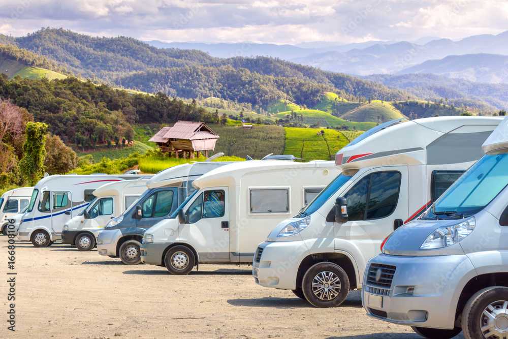Close up motorhomes parked in a row on background green terraced rice field nature landscape. Close up motorhomes parked in a row on background green terraced rice field nature landscape.