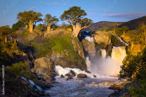 Obraz wodospad ze skałami i bujną roślinnością