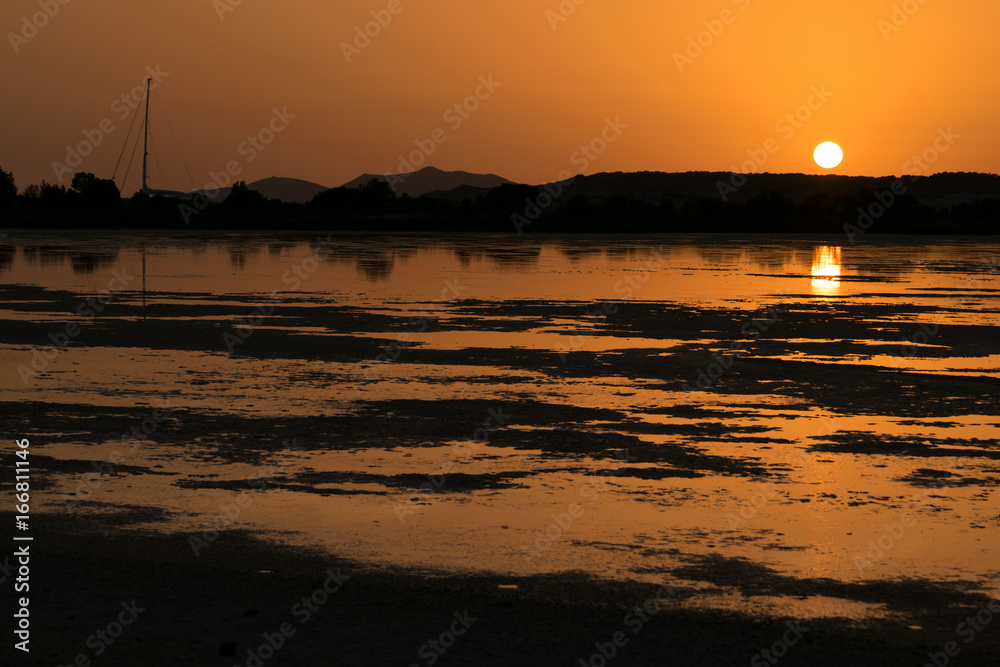 Sunset on the pond of pink flamingos in Chia, Sardinia.