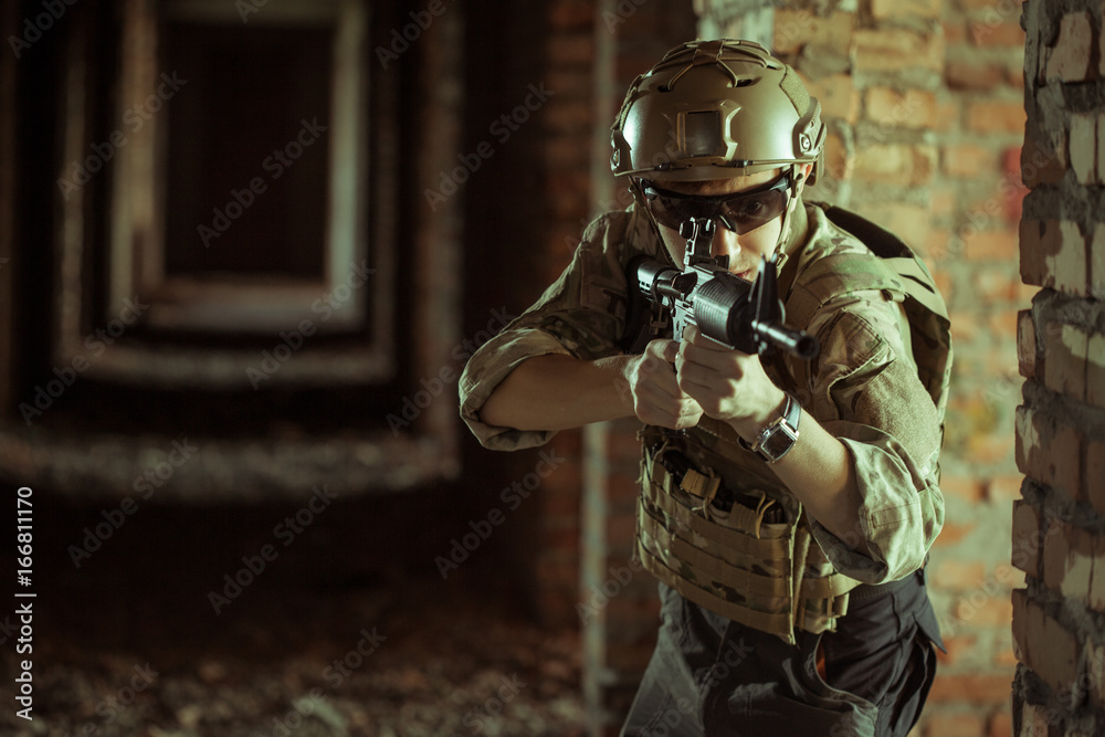 airsoft soldier with a rifle playing strikeball In brick building airsoft soldier with a rifle playing strikeball In brick building