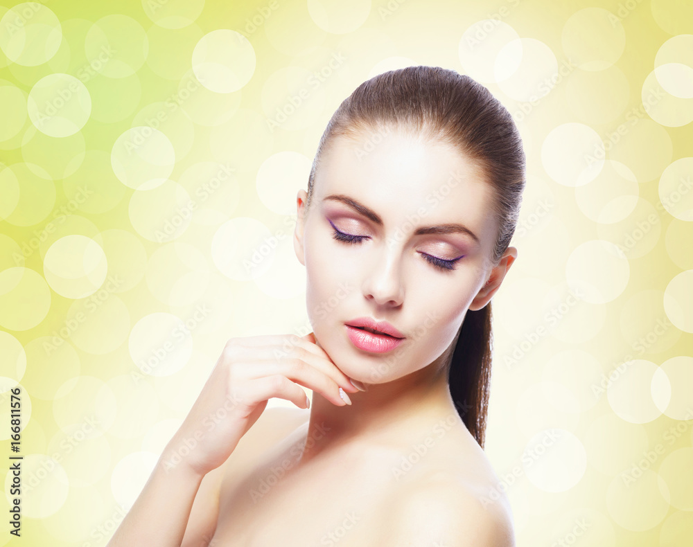 Naklejka premium Portrait of young, beautiful and healthy woman: over yellow background. Healthcare, spa, makeup and face lifting concept.