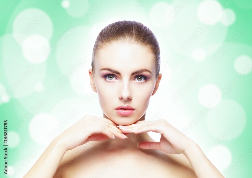 Naklejka premium Portrait of young, beautiful and healthy woman: over teal background. Healthcare, spa, makeup and face lifting concept.
