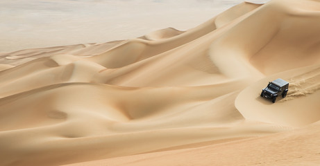 Poster Woestijnlandschap Auto rijdt door Rub al Khali  © katiekk2