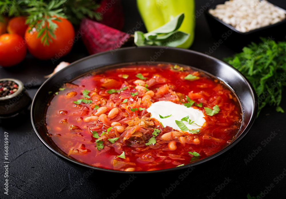 Traditional Ukrainian Russian borscht with white beans on the black bowl Traditional Ukrainian Russian borscht with white beans on the black bowl