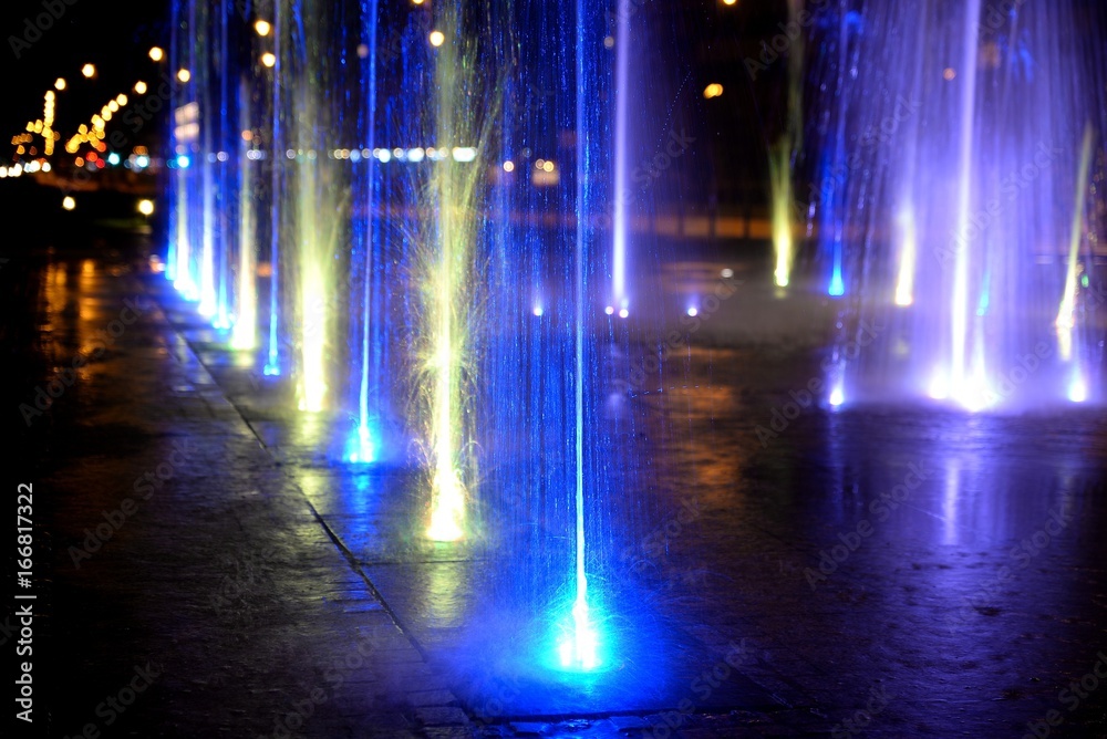City fountain hot summer night and colorful illuminations