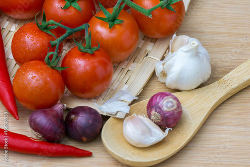 onion garlic and tomato on wooden table. top view