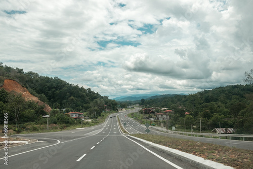 Dramatic scenic top view on curved asphalt road going to the mountains and sky. Target concept. Empty highway on Borneo island, Sabah, Malaysia © Tatiana