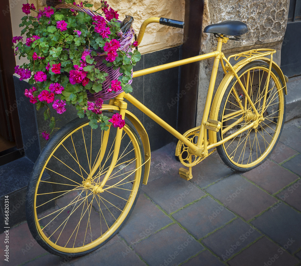 Yellow bicycle with flower basket
