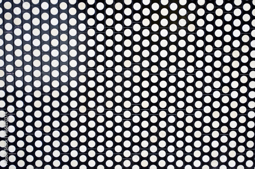 White circles on a black metallic background in the form of a tile