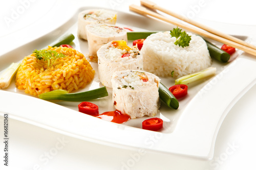 Roast, stuffed chicken roulade with rice and vegetables on white background 