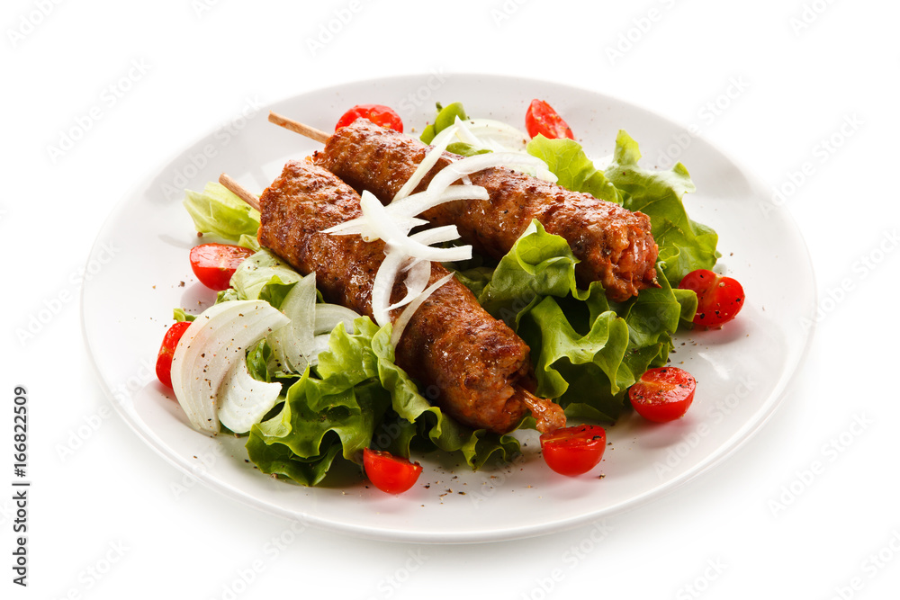 Kebabs - grilled meat and vegetables on white background Kebabs - grilled meat and vegetables on white background