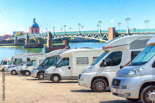 Close up motorhomes parked in a row on background The Saint-Pierre bridge passes over the Garonne river in Toulouse, France