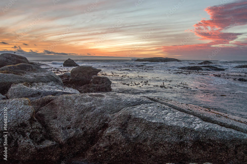 Sunset over rocky beach in Cape Town
