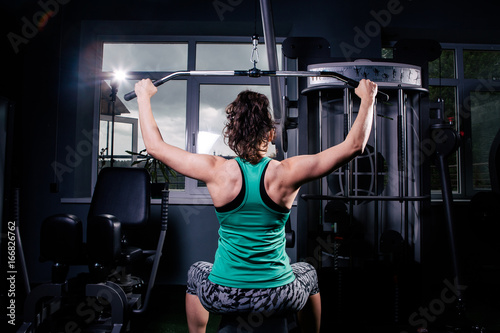 Photography A back view of a trained girl doing exercises