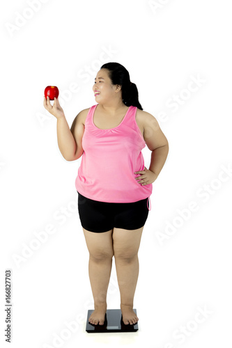 Happy fat woman with scale and apple