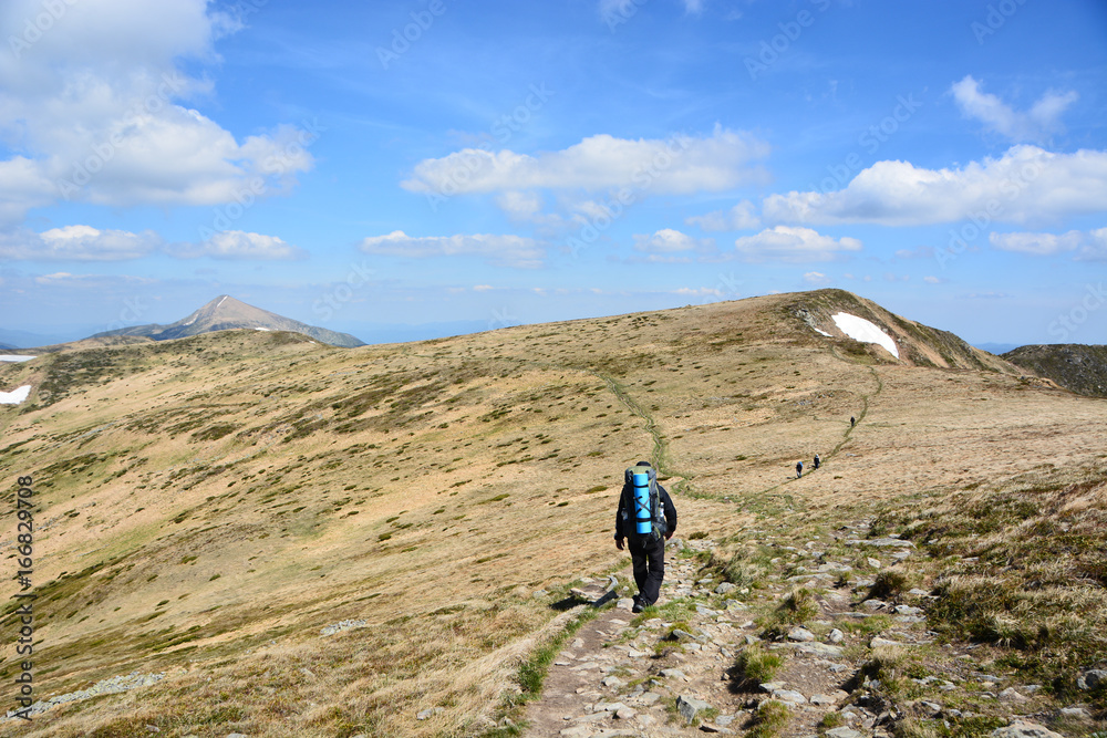 The tourist walks along the trail in the mountains