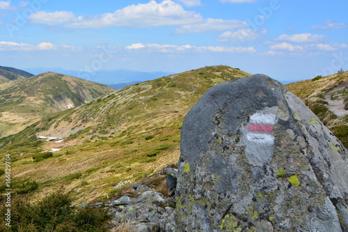 A stone with a route mark on the background of the mountains