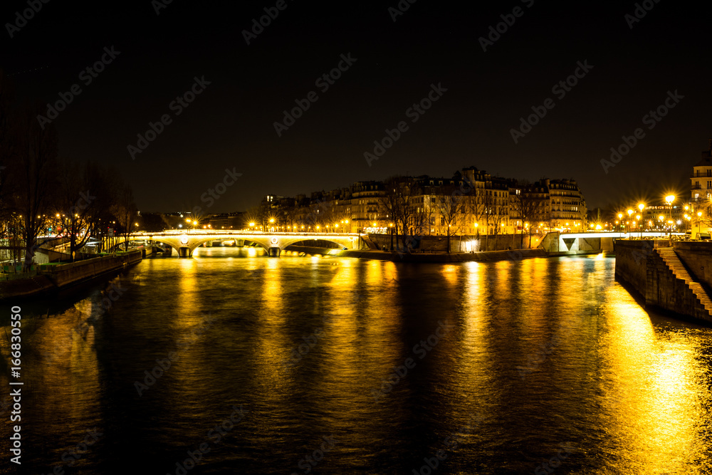 Night urban scene of a calm river crossing a big city