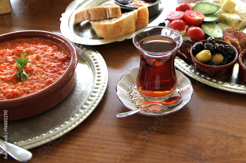  Traditional Turkish breakfast with menemen in a earthenware bowl.