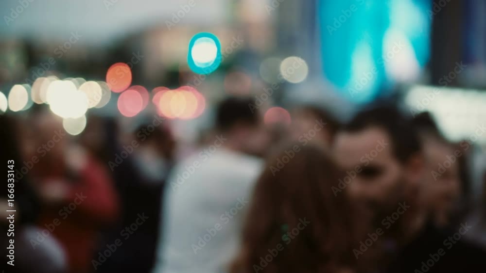 Blurred view of many people dancing the latin or salsa at open-air festival. Men and women having fun together.