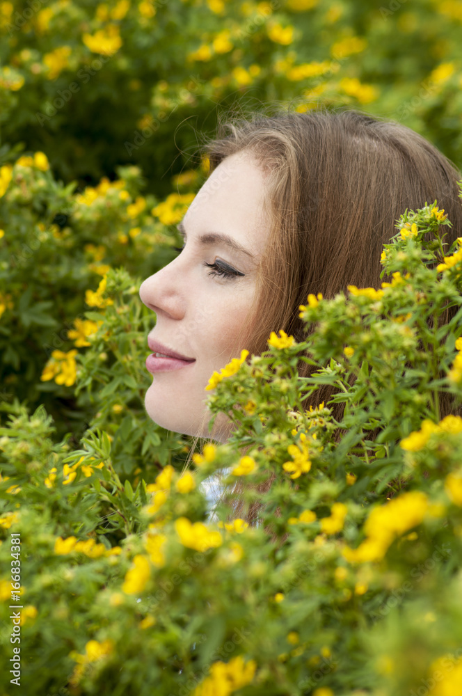 Portrait of girl on a background of yellow flowers. Portrait of girl on a background of yellow flowers.