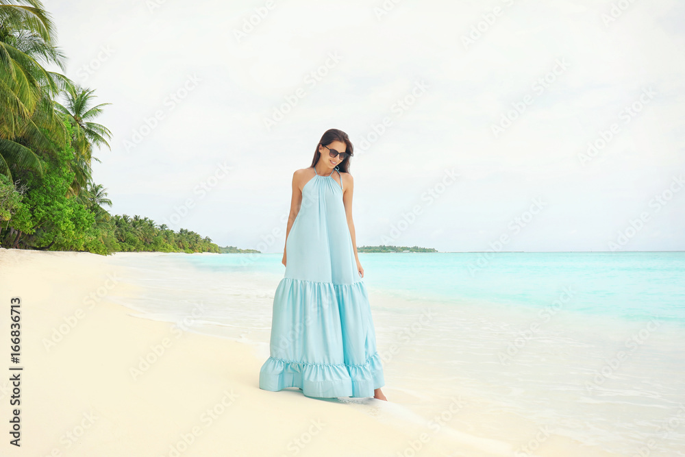 Beautiful young woman on sea beach at tropical resort Beautiful young woman on sea beach at tropical resort