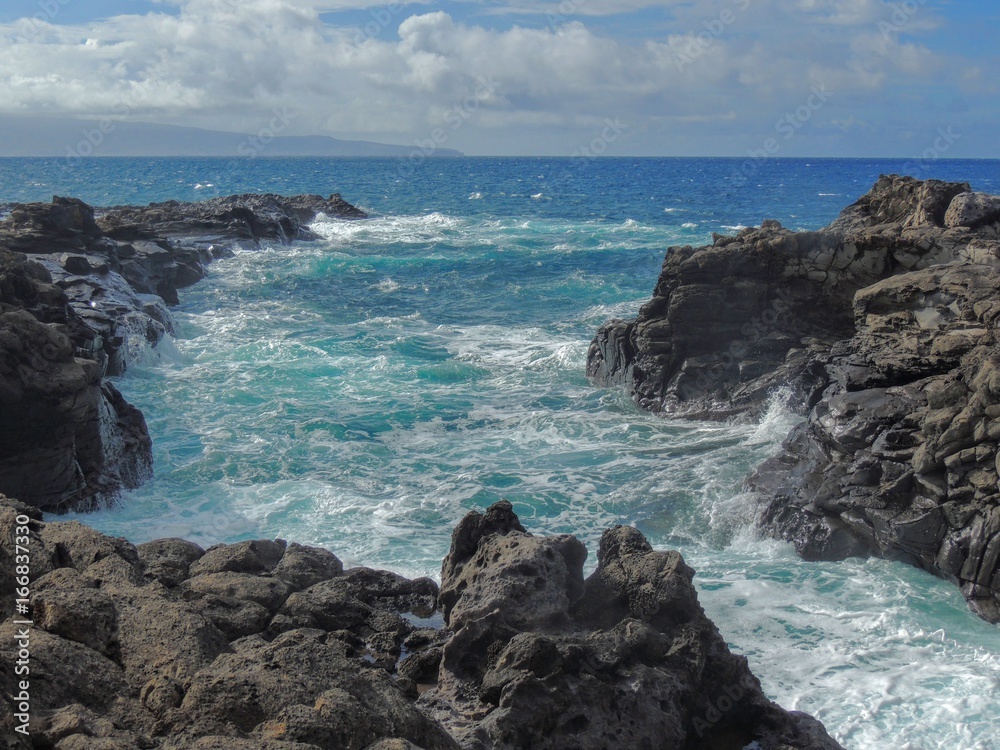 Coastline and rugged lava rocks called Dragon’s Teeth and crashing waves at Makaluapuna Point near Kapalua, Maui, HI, USA