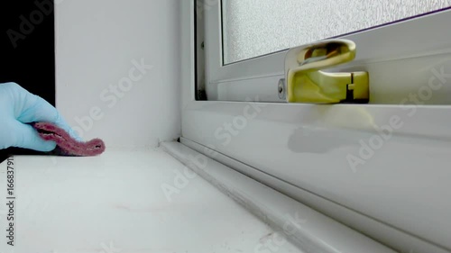 Man rubbing down windowsill with an abrasive pad photo