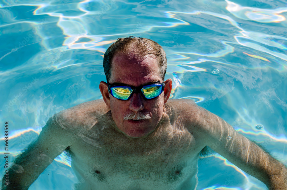 Mature man in a swimming pool, looking up