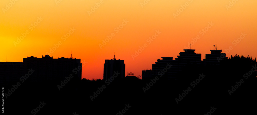 City buildings on a yellow sunset as a background