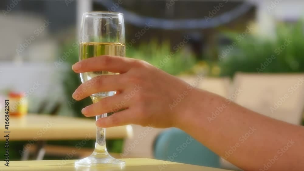 Hand raising a glass of champagne. Bubbles close-up. 4k. Hand raising a glass of champagne. Bubbles close-up. 4k.
