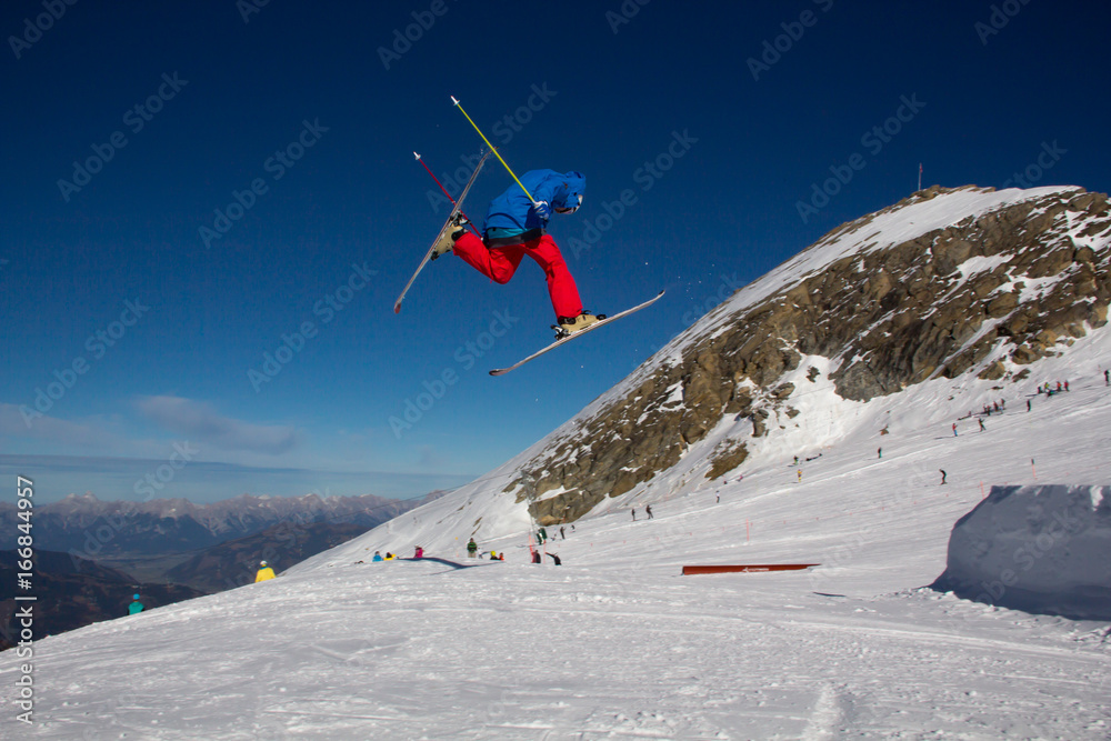 A male skier jumping over an obstacle in the Kitzsteinhorn Funpark in the alps of Austria