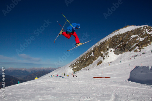A male skier jumping over an obstacle in the Kitzsteinhorn Funpark in the alps of Austria