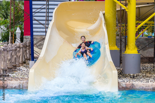 asian teenagers enjoying their water slider ride at a water theme park
