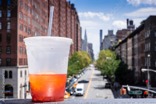 Ice tea in a plastic cup on a bench overlooking 10th Avenue  photo