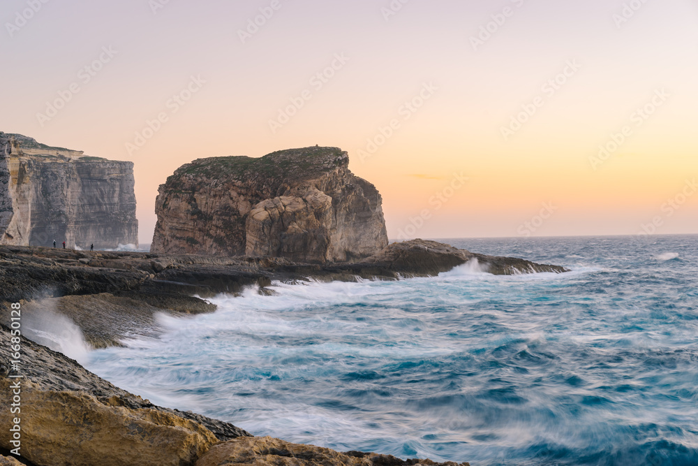 Gozo Island cliffs with Fungus Rock (small islet) during the spring storm. Dwejra, Maltese archipelago