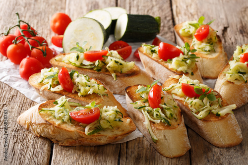 Tasty Italian sandwiches with zucchini and tomatoes close-up and ingredients. horizontal
