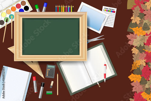 Blank green chalkboard in the centre of the vector is surrounded by school equipment. Colorful autumn leaves form the right edge of the vector.