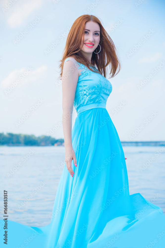 Young red hair woman in blue evening dress laughing and smile have fun on a yacht. Concept of positive life and dreaming about pure future Young red hair woman in blue evening dress laughing and smile have fun on a yacht. Concept of positive life and dreaming about pure future