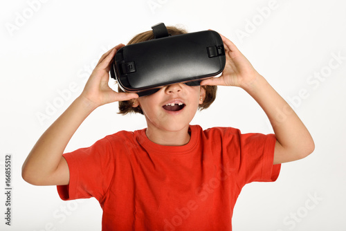 Little girl looking in VR glasses and gesturing with his hands.