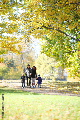 Family with children walking in autumn park © alotofpeople