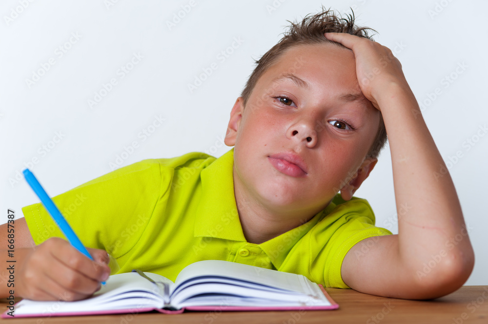 Portrait of tired schoolboy sitting with book Portrait of tired schoolboy sitting with book