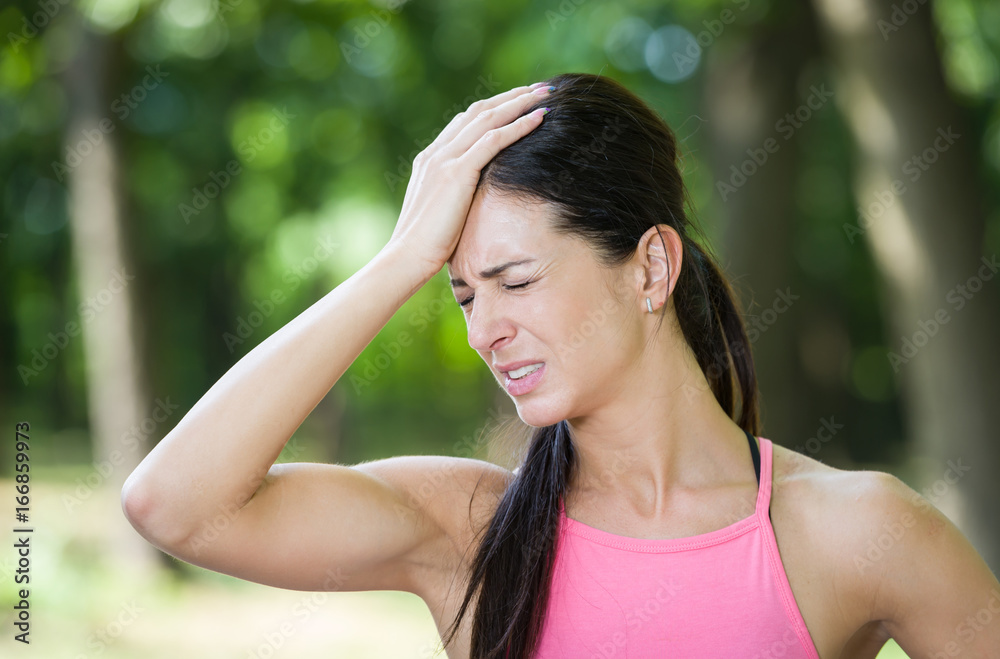 fitness woman headache in a park