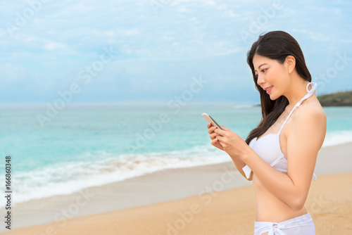 elegant woman wearing bikini standing on beach