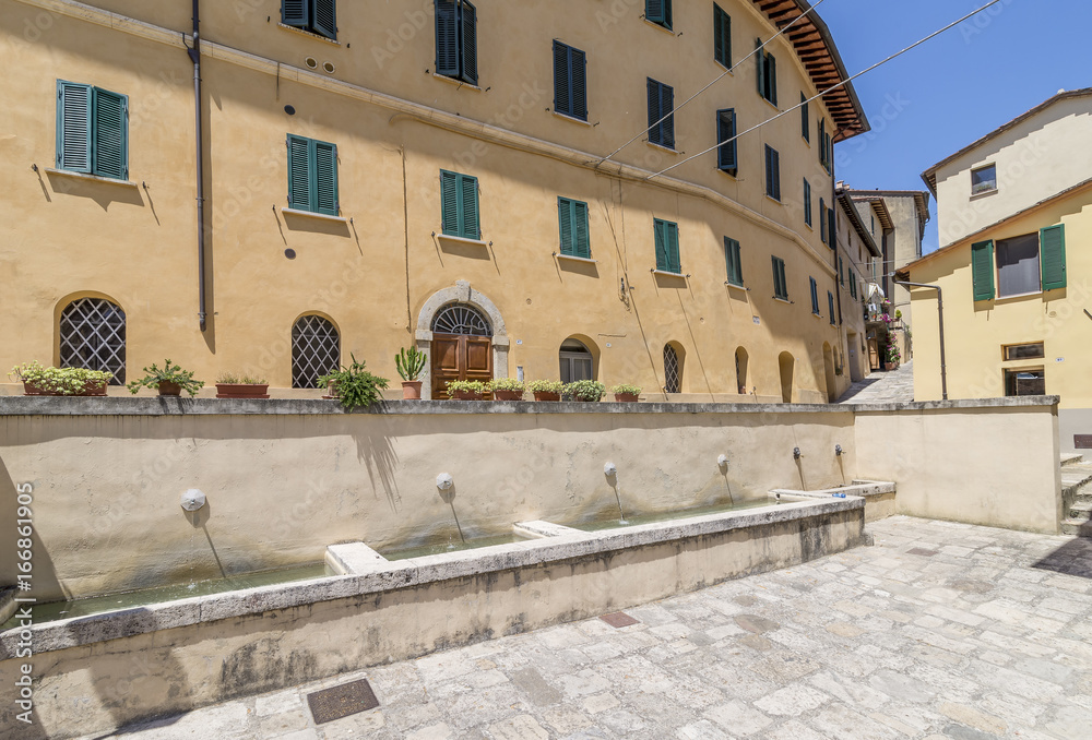 Small fountains and tubs in Piazza Garibaldi square, historic center of Cetona, Siena, Italy, on a sunny day