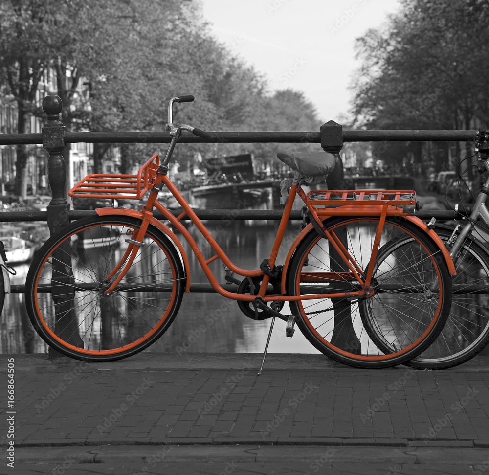 Black and white view of Amsterdam with orange bicycle