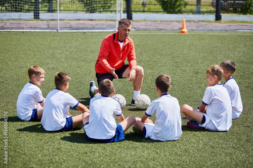 Bilde på lerret Coach Instructing Junior Football Team in Practice