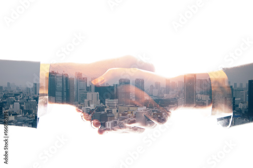 double exposure of shaking hands and urban skyline. abstract mixed media.